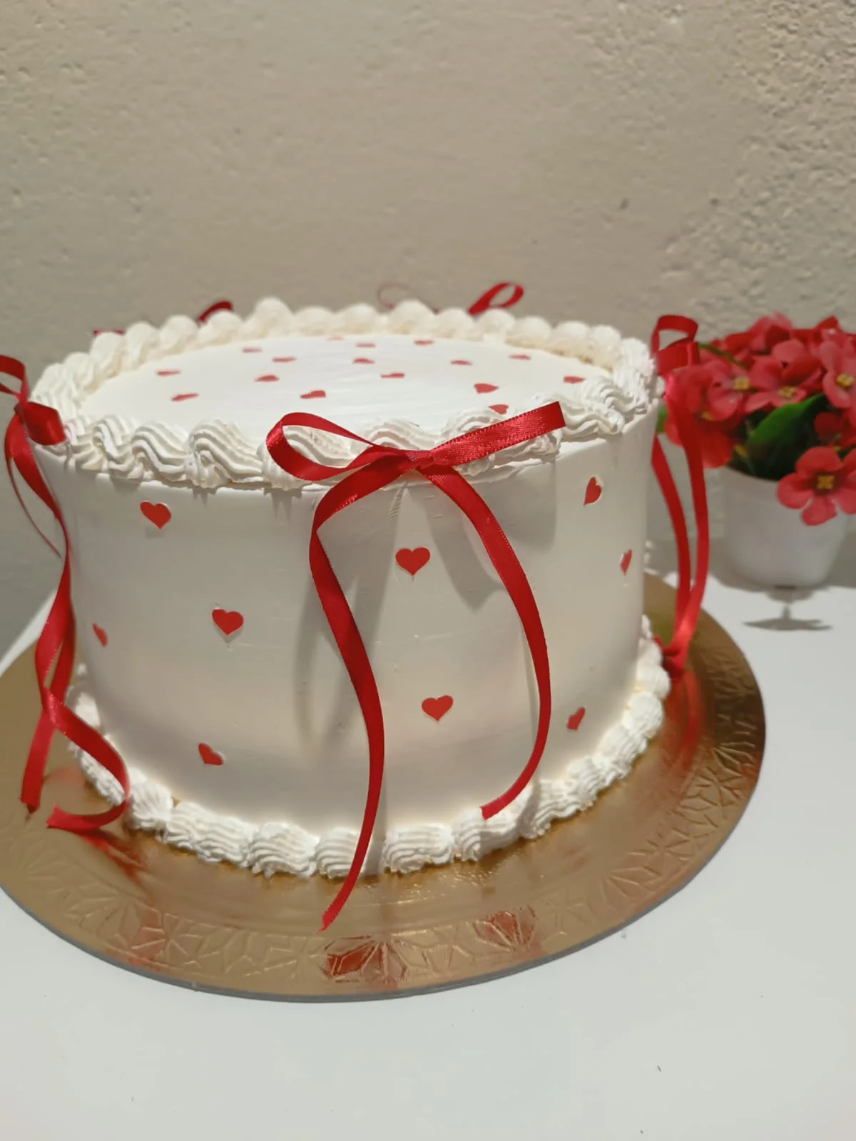 Bolo Romântico - Bolo branco decorado com corações vermelhos, ideal para celebrações românticas